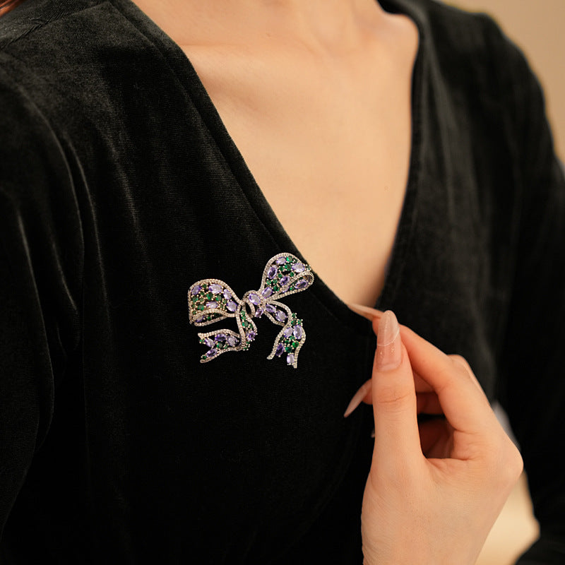 Elegant RosyCozy bow-shaped brooch featuring sparkling purple and green zircons